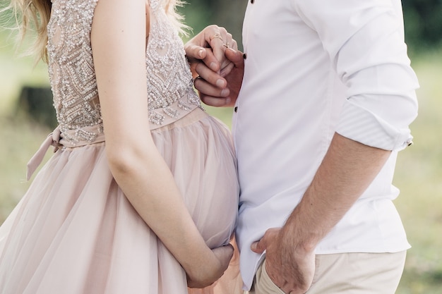 Photo mari tient sa femme enceinte par la main close-up