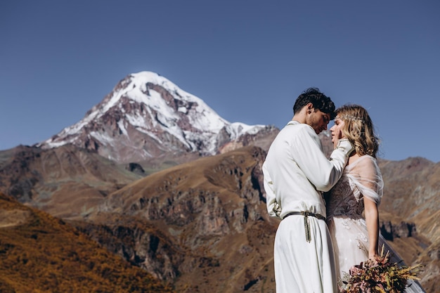 Mariage au sommet des Rocheuses enneigées Couple géorgien aimant des mariées élégantes posant pour la photo