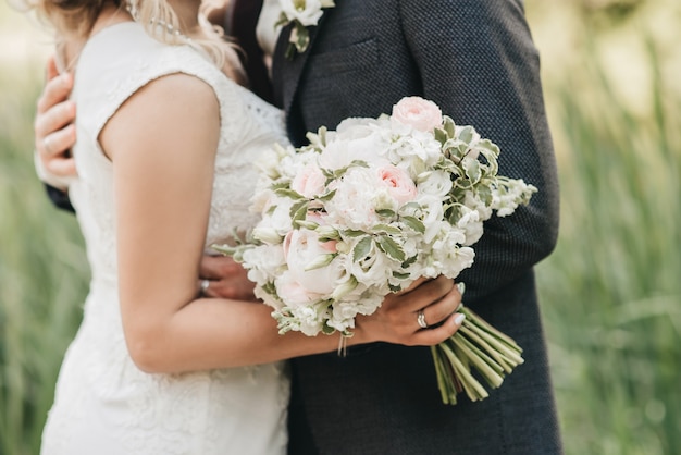 Mariage beau bouquet entre les mains de la mariée