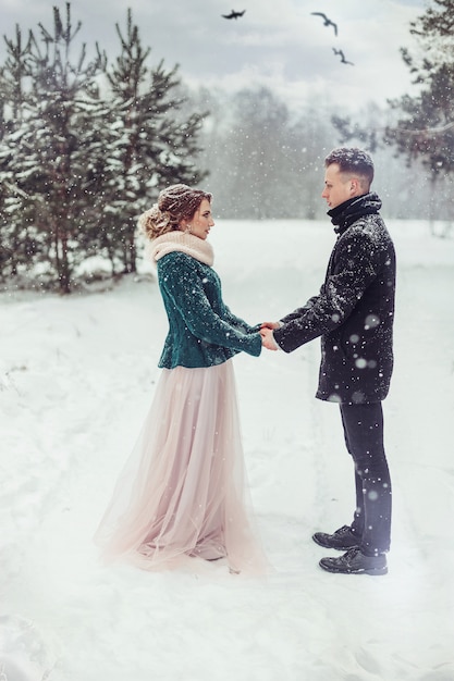 Mariage couple d'amoureux dans la forêt d'hiver enneigée