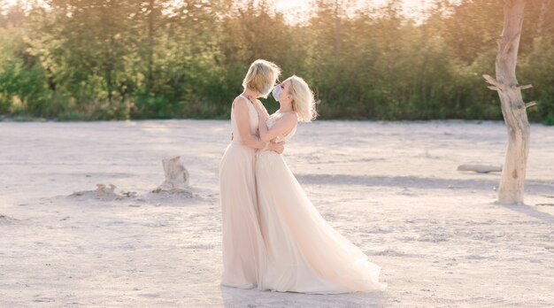 Mariage d'un couple de lesbiennes sur du sable blanc, portez des masques pour prévenir l'épidémie COVID-19