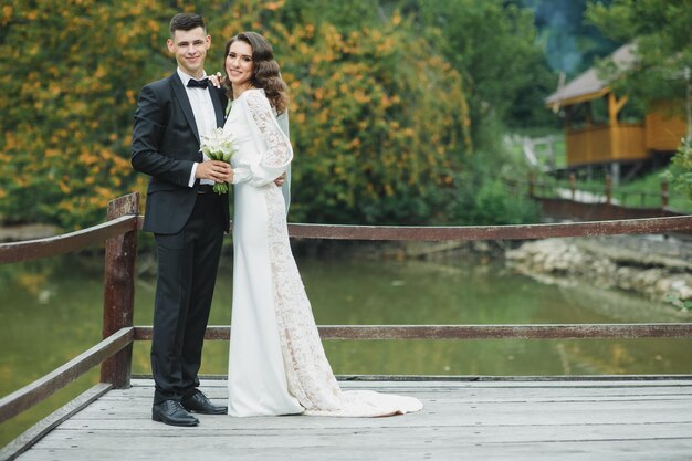 Mariage européen élégant au coucher du soleil. Couple heureux dans la forêt dans la nature.