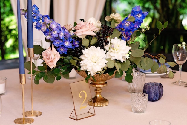 Mariage festif, table avec serviettes en lin bleu, bougies et bouquets de fleurs fraîches. Décorations de mariage. Concept de menu de restaurant. Mise au point sélective douce.