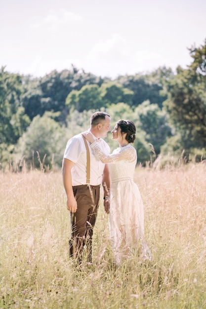 Mariage d'un jeune beau couple dans un style vintage. Jeunes mariés en promenade dans le parc