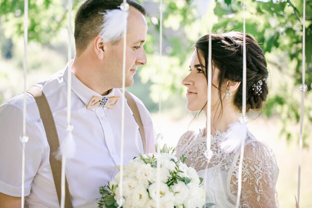 Mariage d'un jeune beau couple dans un style vintage. Jeunes mariés en promenade dans le parc