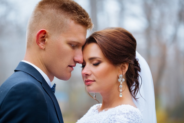 Mariage mariée et le marié embrassant un couple amoureux avec des fleurs de bouquet de roses au jour de la mariée d'hiver Profitez d'un moment de bonheur et de plaisir. femme de famille de jeunes mariés ludique et homme amoureux. magnifique mariée