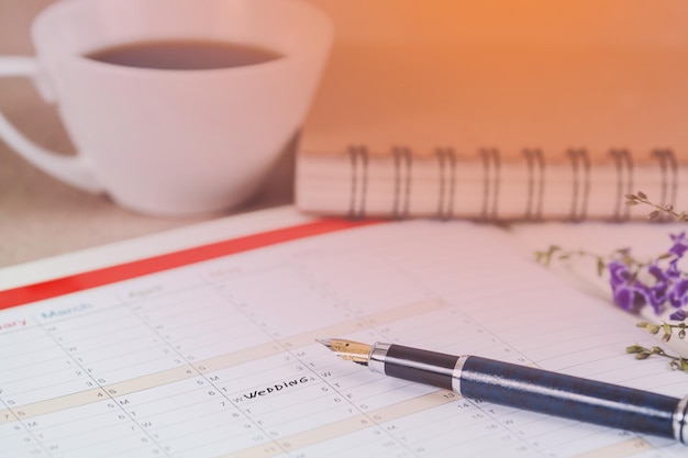 Mariage de mot sur le calendrier avec des fleurs douces et un concept d'amour de stylo