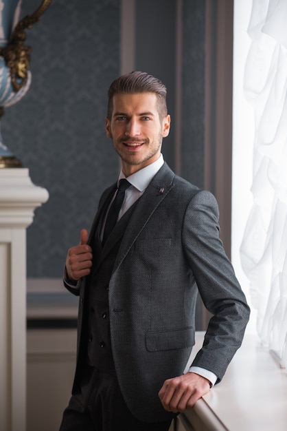 Marié Au Jour Du Mariage Souriant Et Attendant La Mariée Dans Le Hall De L'hôtel. élégant Homme Riche En Costume Et Nœud Papillon.