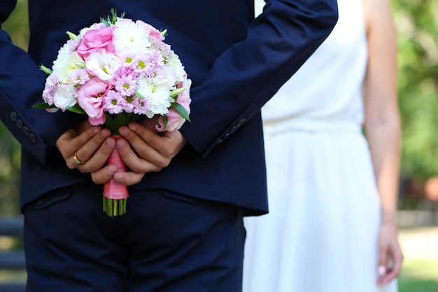 Marié avec bouquet de mariée et mariée sur fond de nature