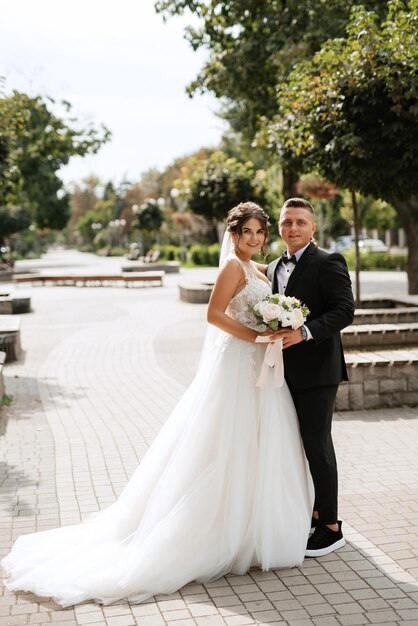 Photo le marié en costume brun et la mariée en robe blanche.