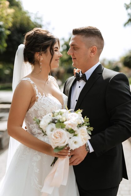 Le marié en costume brun et la mariée en robe blanche.