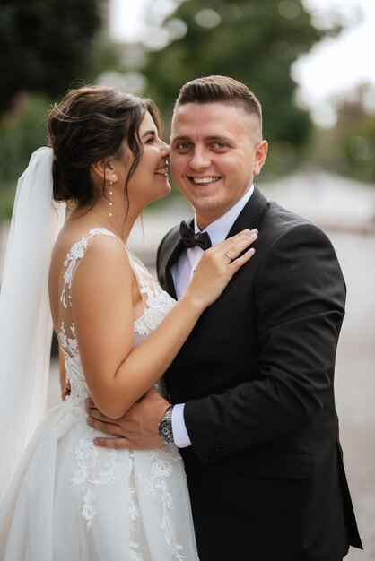 Photo le marié en costume brun et la mariée en robe blanche.