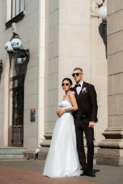 Le marié en costume marron et la mariée en robe blanche