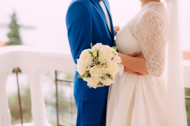 Le marié embrasse la mariée sur le mariage sur la plage au Monténégro