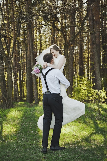 Photo le marié encerclant la mariée dans ses bras 4078