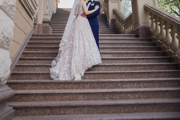 Marié avec la jeune mariée sur les grands escaliers en parc