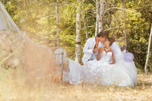 Le marié et la mariée dans la forêt sur un lit