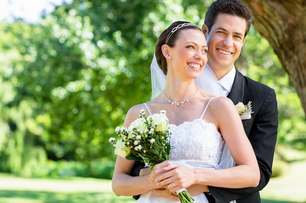 Le marié et la mariée debout dans le jardin