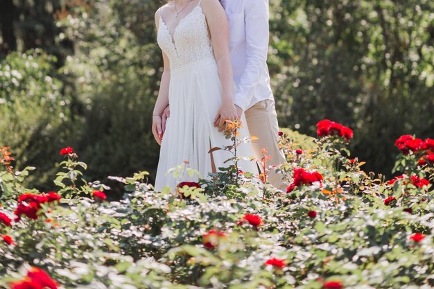 Marié avec la mariée en robe de mariée dans le parc d'été