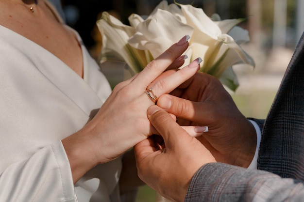 Photo le marié met une bague en or sur le doigt de la mariée pendant la cérémonie de mariage.