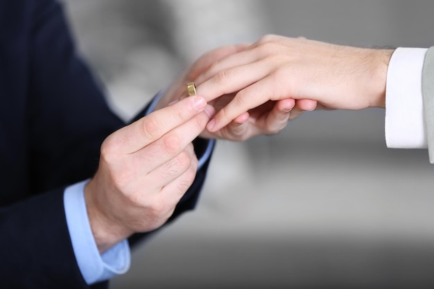 Photo un marié plaçant la bague au doigt d'un autre homme