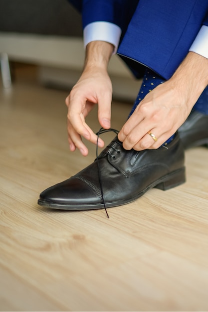 Le marié porte des chaussures en costume de mariage bleu