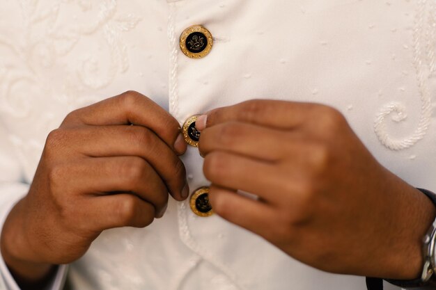 Photo le marié resserre ses boutons de manchette avant le mariage