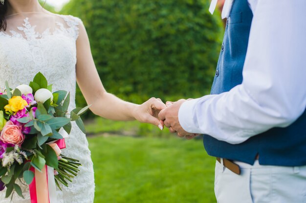 Marié tenant la main de sa mariée