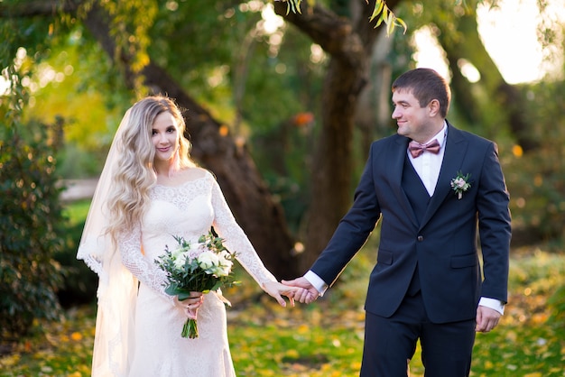 Le marié tient doucement la main de sa mariée