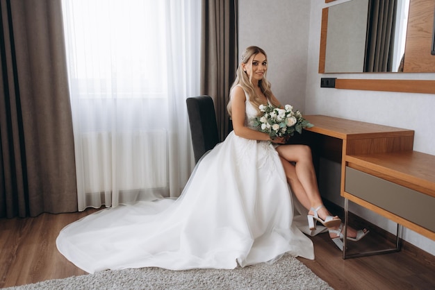 Mariée assise à un bureau dans une chambre d'hôtel