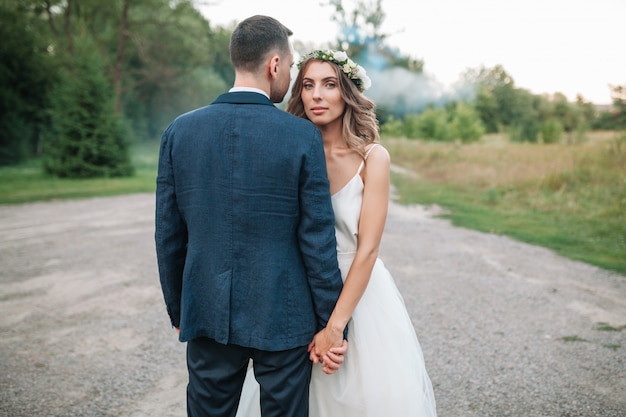 Mariée au marié au jour de mariage marche à l&#39;extérieur sur la nature de l&#39;été