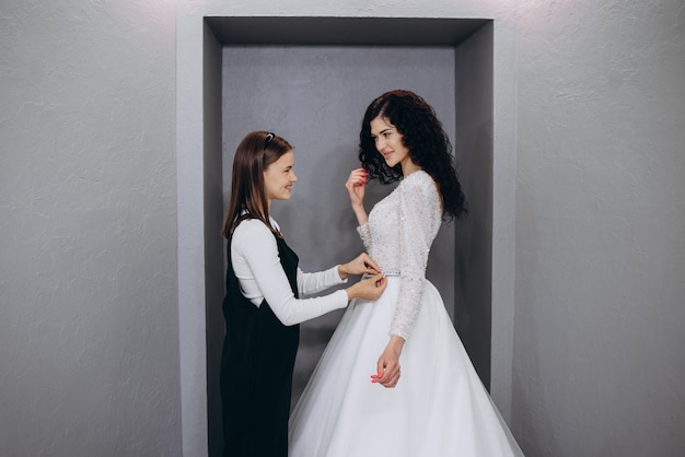 Mariée à la boutique de vêtements pour les robes de mariée, elle choisit une robe et le créateur l'aide