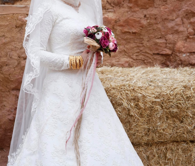 Mariée avec bracelets en or et bouquet