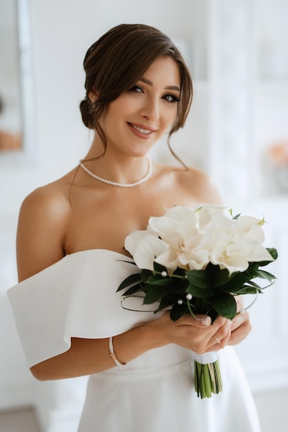 Mariée brune dans une robe de mariée serrée dans un studio lumineux