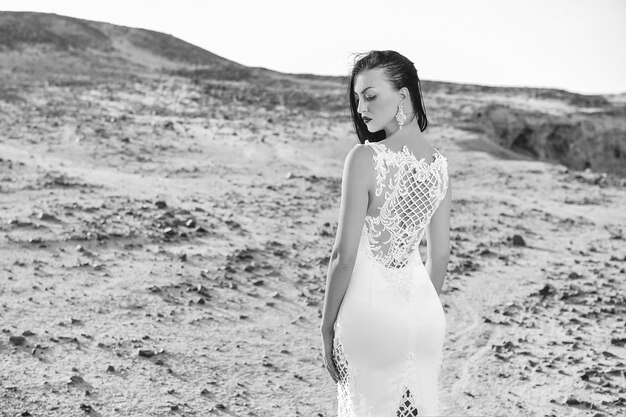 Mariée et cérémonie de mariage Fille en robe dans le désert ensoleillé Mode de mariage et salon de beauté Élégance et mannequin Femme en robe blanche dans les dunes de sable