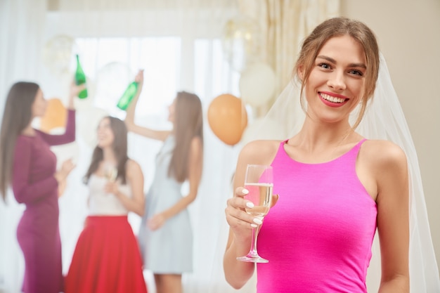 Mariée avec champagne assis à l'enterrement de vie de jeune fille.