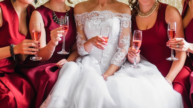 mariée et copines heureuses avec des verres de vin dans leurs mains tinter et célébrer