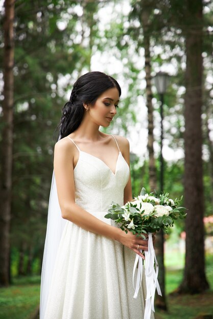Mariée dans une belle robe blanche avec un bouquet de fleurs