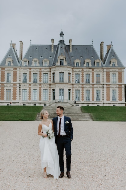 Mariée dans une belle robe de mariée, marié dans un élégant smoking, allez à l'ancien château en France