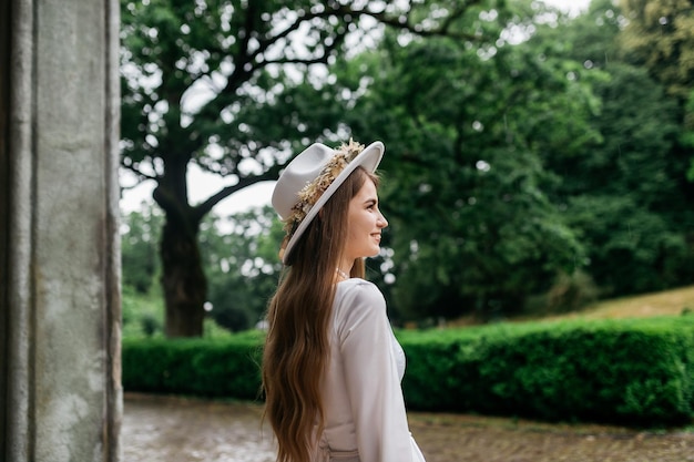 La mariée dans un chapeau et un bouquet Portrait d'une mariée dans une robe blanche Portrait de la mariée Jeune fille dans une robe de mariée blanche et un chapeau avec un bouquet de fleurs