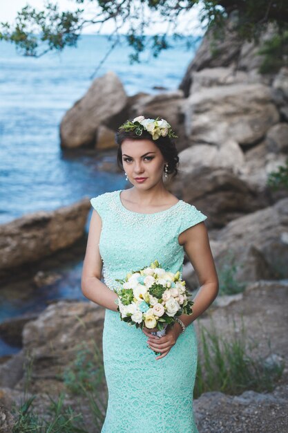 Mariée dans la nature dans les montagnes près de l'eau