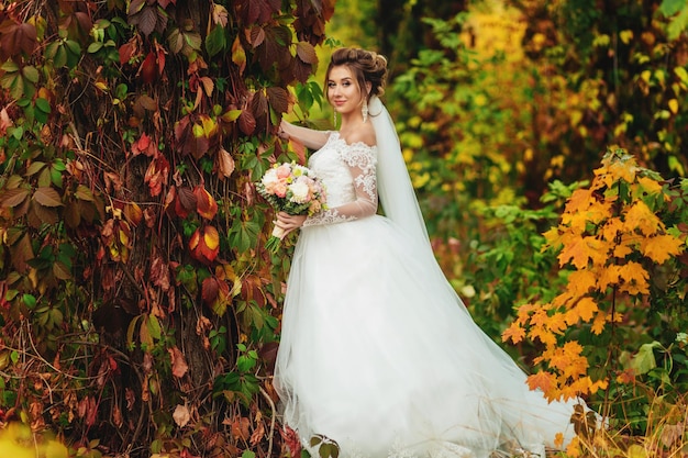 Mariée dans un parc d'automne coloré