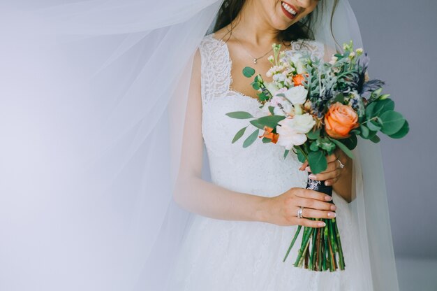 La mariée dans une robe blanche tient un beau bouquet