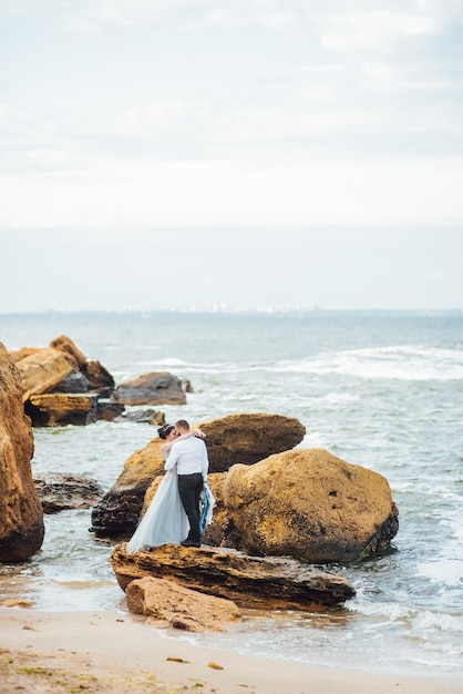 mariée dans une robe bleue marche le long du rivage de l'océan