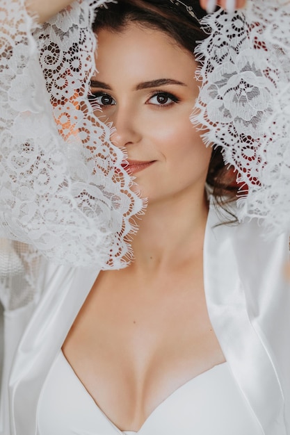 Photo la mariée dans une robe ouverte buste ouvert grande coiffure robe de dentelle portrait en gros plan regardant dans la caméra