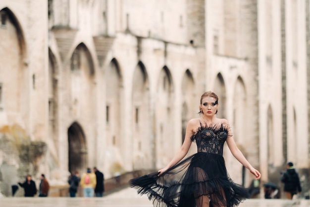 Une mariée élégante dans une robe de mariée noire pose dans l'ancienne ville française d'Avignon. Modèle dans une belle robe noire. Séance photo en Provence.