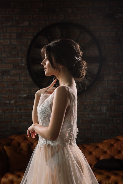 La mariée est une brune d'apparence européenne. Portrait unique. Maquillage et coiffure de mariage. Matin de la mariée. Boudoir à l'hôtel.