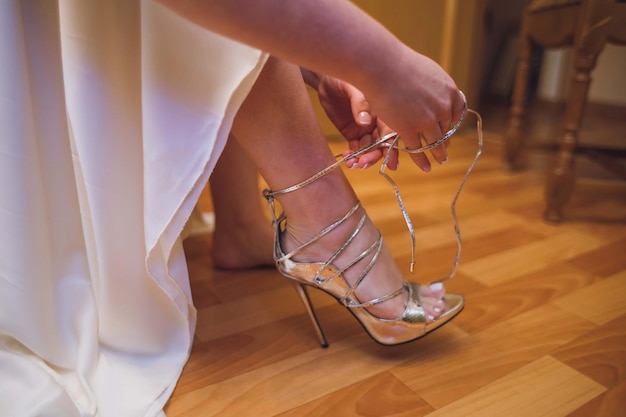 La mariée habille des chaussures avant la cérémonie de mariage de la mariée gros plan détail de la mise de la mariée