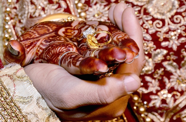 Une mariée indienne et le marié tenant leurs mains avec bague lors d'un rituel de mariage hindou