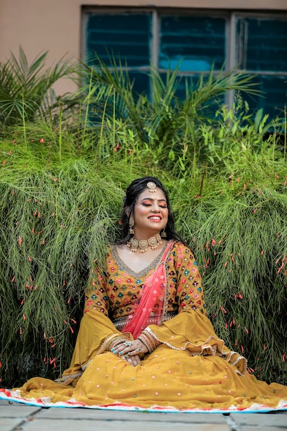 mariée indienne portant des lengha traditionnels et des bijoux avec un beau visage